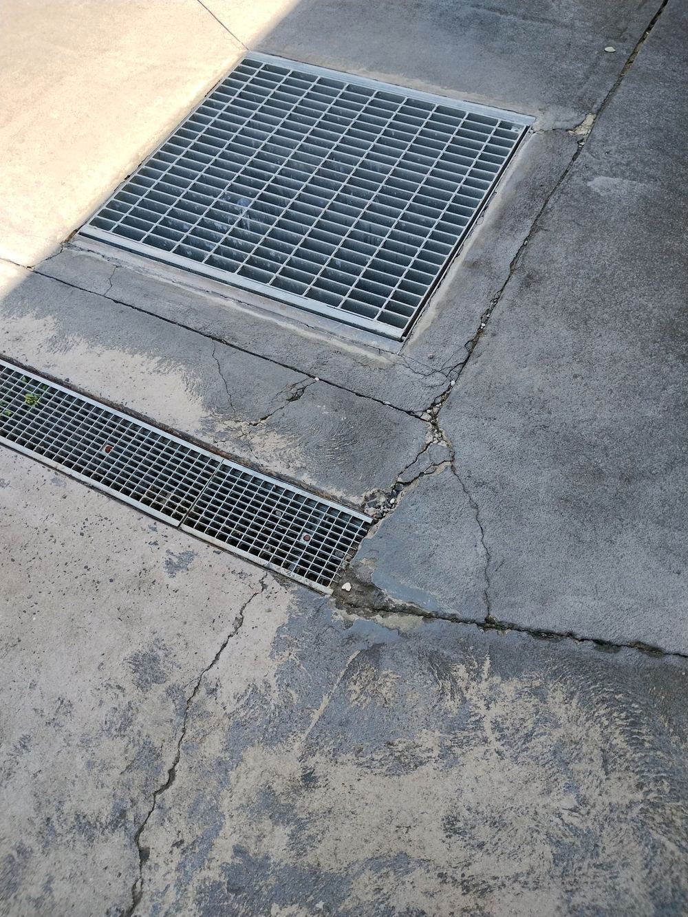 Wide crack running out from a pit grate across the concrete, Blacktown, Gables